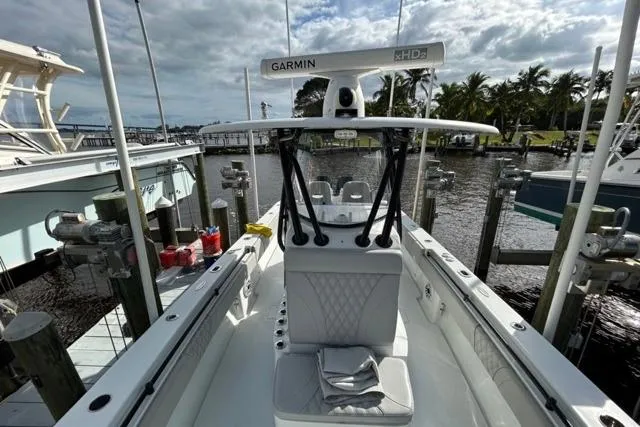 Slide: The Image of 2023 Contender 32 ST boat docked, featuring Garmin equipment, with a scenic waterfront view. - 24