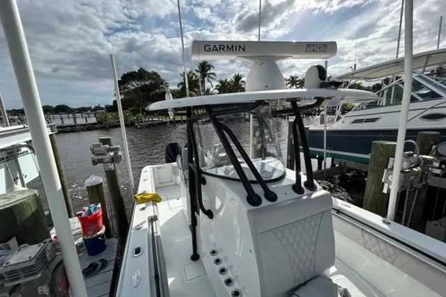 Slide: The Image of 2023 Contender 32 ST boat docked, featuring Garmin radar, under a cloudy sky. - 25