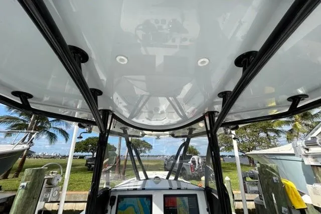 Slide: The Image of 2023 Contender 32 ST boat interior with navigation screens, docked near palm trees. - 30
