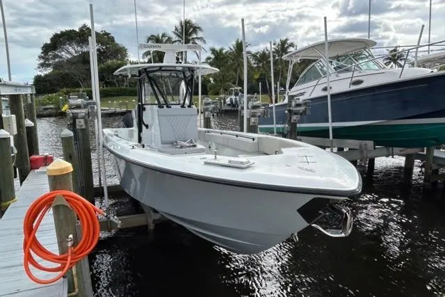 Slide: The Image of 2023 Contender 32 ST boat docked at marina with palm trees in background. - 33