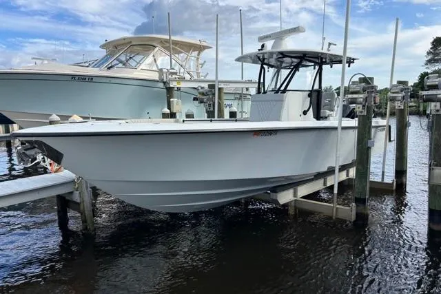 Slide: The Image of 2023 Contender 32 ST boat docked on a lift, with clear skies and water. - 34