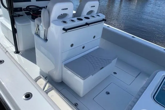 Slide: The Image of 2023 Contender 32 ST boat interior with seating and storage, docked by the water. - 8