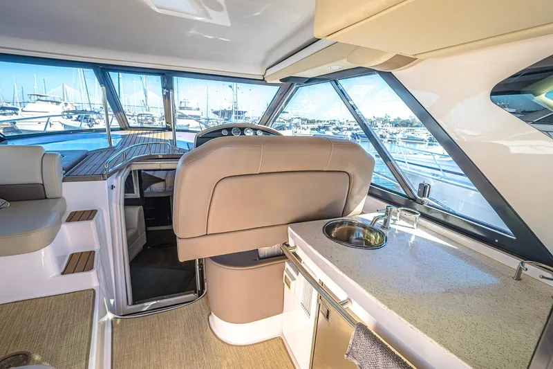 Slide: The Image of Interior of 2016 Regal 46 Sport Coupe yacht with helm and kitchenette. - 14