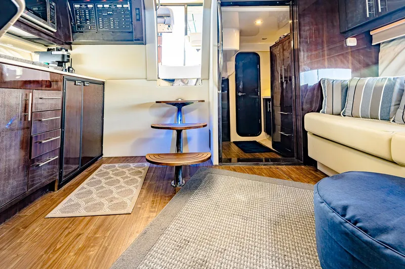 Slide: The Image of Interior of 2016 Regal 46 Sport Coupe yacht with modern kitchen and cozy seating area. - 25