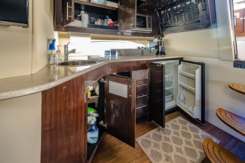Slide: The Image of 2016 Regal 46 Sport Coupe yacht kitchen with open cabinets and modern amenities. - 28