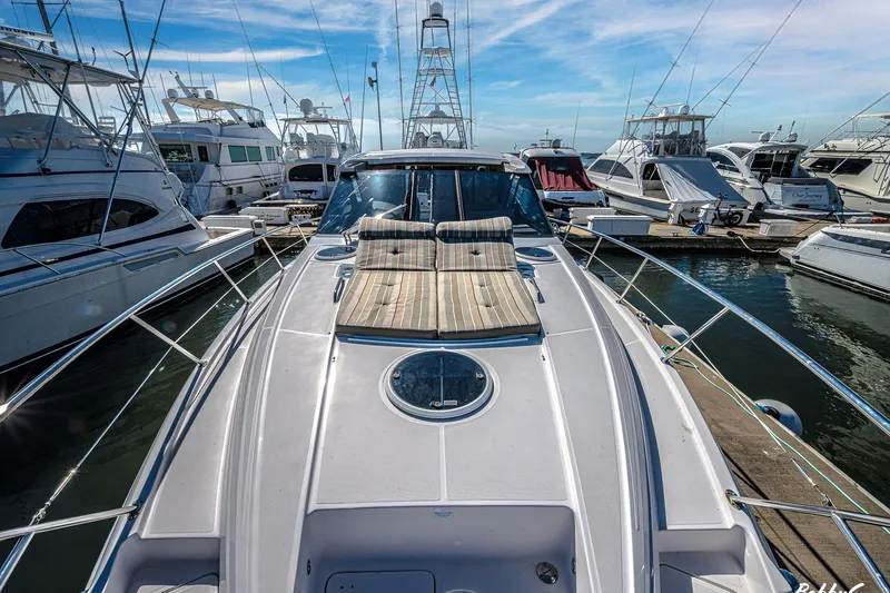 Slide: The Image of 2016 Regal 46 Sport Coupe yacht docked at marina, surrounded by other boats. - 40