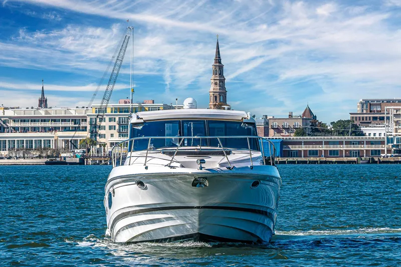 Slide: The Image of 2016 Regal 46 Sport Coupe yacht cruising near urban waterfront skyline. - 5