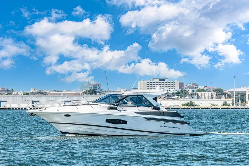 Slide: The Image of 2016 Regal 46 Sport Coupe cruising on water under a bright blue sky. - 51