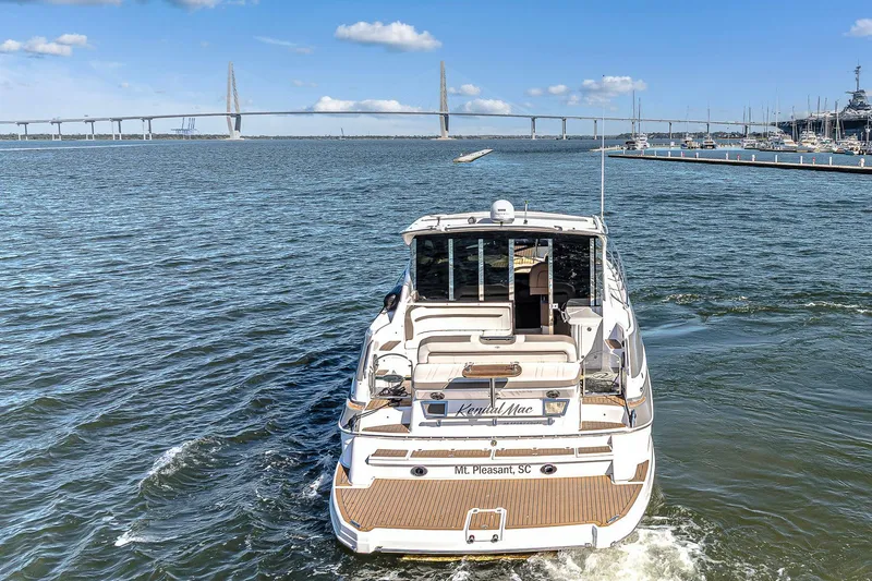 Slide: The Image of 2016 Regal 46 Sport Coupe yacht cruising near a bridge on a sunny day. - 6