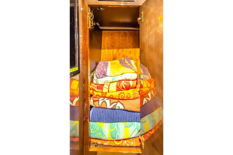 Slide: The Image of Stacked colorful towels in a wooden cabinet aboard a 2016 Regal 46 Sport Coupe. - 61