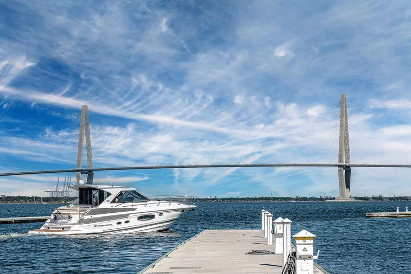 Slide: The Image of 2016 Regal 46 Sport Coupe cruising near a bridge under a clear blue sky. - 79