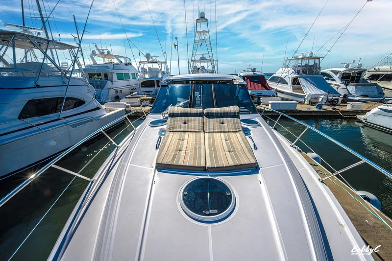 Slide: The Image of 2016 Regal 46 Sport Coupe yacht docked at marina under blue sky. - 8