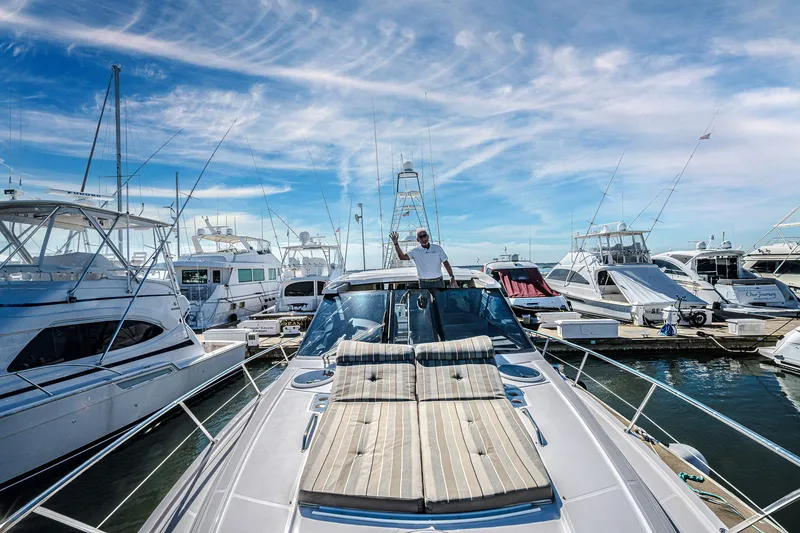 Slide: The Image of 2016 Regal 46 Sport Coupe yacht docked at marina under blue sky. - 81