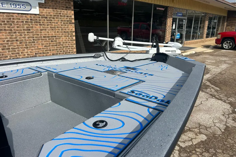 Slide: The Image of 2026 Xpress H20B Bay boat with Minn Kota motor, displayed outside a store. - 4