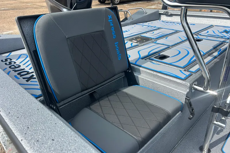 Slide: The Image of 2026 Xpress H20B Bay boat seat with blue accents and textured flooring. - 7