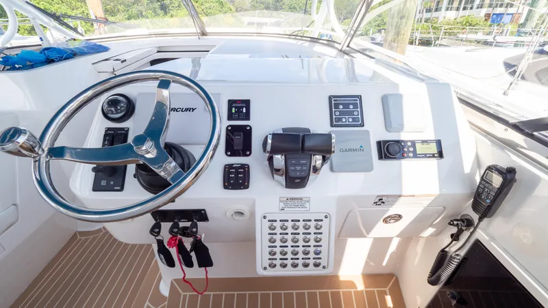 Slide: The Image of 2018 Intrepid 430 Sport Yacht helm with steering wheel and navigation controls. - 15