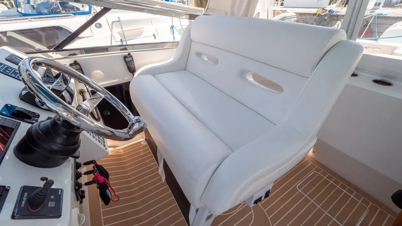Slide: The Image of 2018 Intrepid 430 Sport Yacht helm with white seating and modern controls. - 29