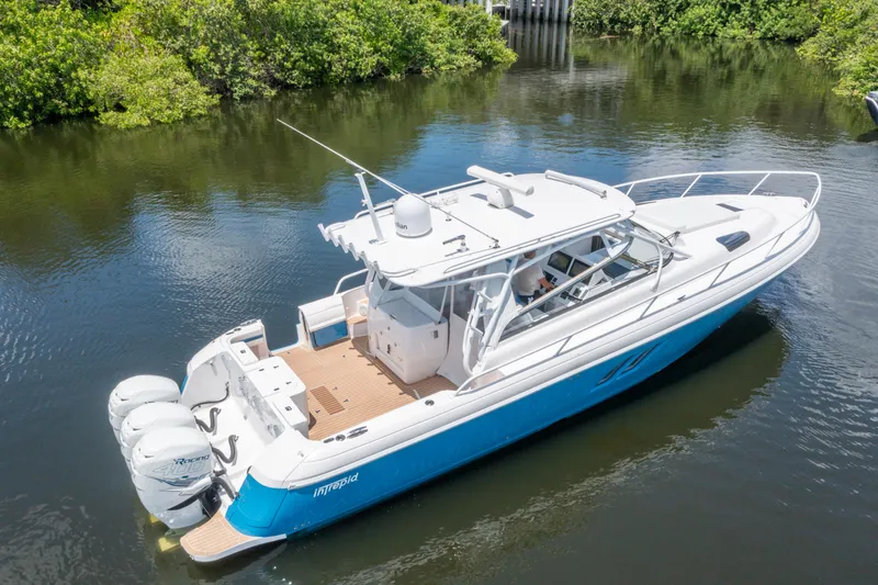 Slide: The Image of 2018 Intrepid 430 Sport Yacht cruising on a calm river, surrounded by lush greenery. - 32