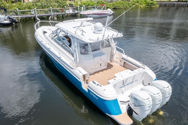 Slide: The Image of 2018 Intrepid 430 Sport Yacht with triple outboard engines on calm water. - 34