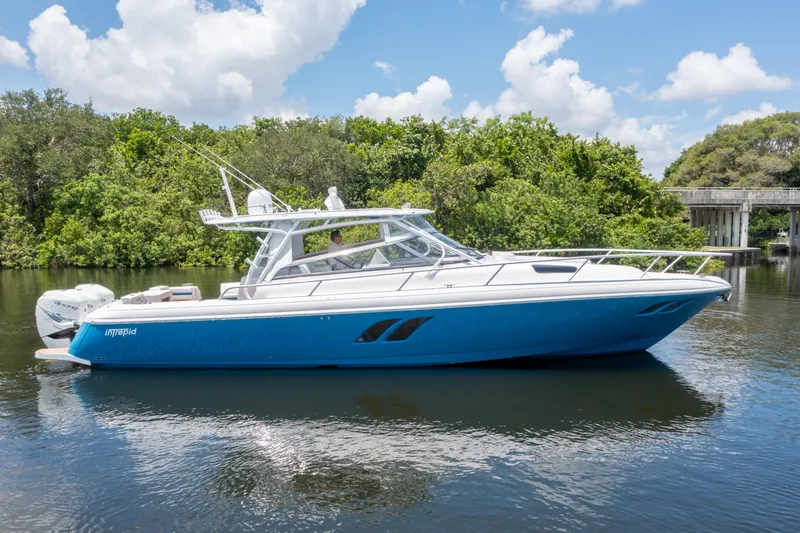 Slide: The Image of 2018 Intrepid 430 Sport Yacht on calm water, surrounded by lush greenery. - 35