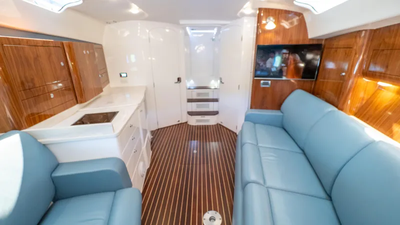 Slide: The Image of Interior of 2018 Intrepid 430 Sport Yacht with blue seating and wood accents. - 39