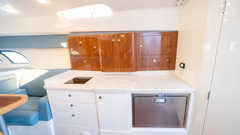 Slide: The Image of 2018 Intrepid 430 Sport Yacht interior with modern kitchen and wooden cabinetry. - 47
