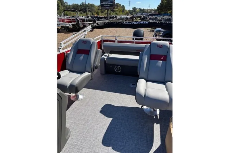 Slide: The Image of 2026 Sun Tracker Party Barge 22 RF DLX interior with gray seating and red accents. - 6