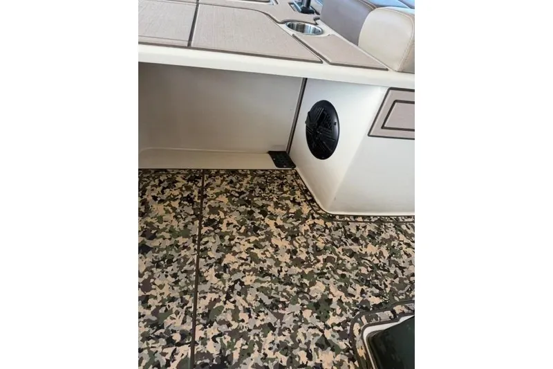 Slide: The Image of 2026 Mako 18 Pro Skiff Backwater Edition interior with camo flooring and speaker. - 12