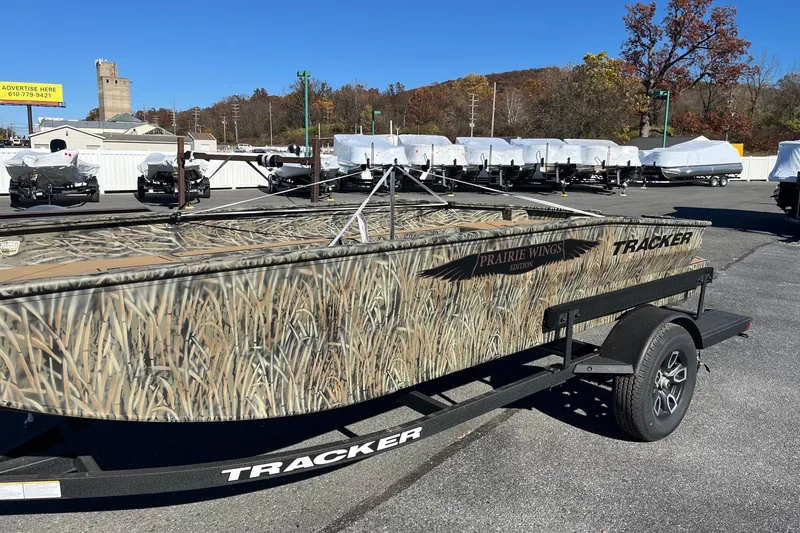 Slide: The Image of 2026 Tracker Grizzly 1650 T Prairie Wings Edition boat with camouflage design on a trailer. - 34