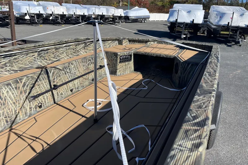 Slide: The Image of 2026 Tracker Grizzly 1650 T Prairie Wings Edition boat with camouflage interior, parked outdoors. - 35