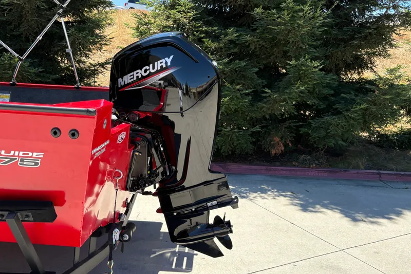 Slide: The Image of 2026 Tracker Pro Guide V-175 WT boat with Mercury outboard motor, parked outdoors. - 13