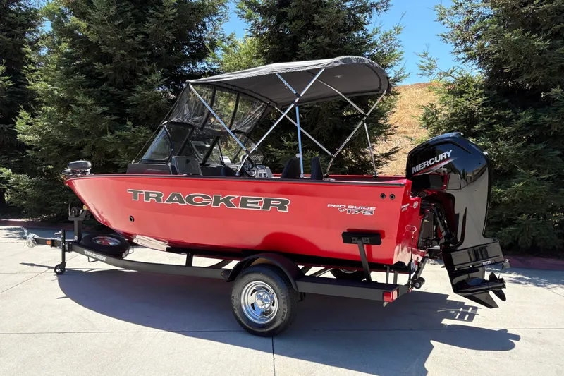 Slide: The Image of 2026 Tracker Pro Guide V-175 WT boat with Mercury engine, parked outdoors. - 2