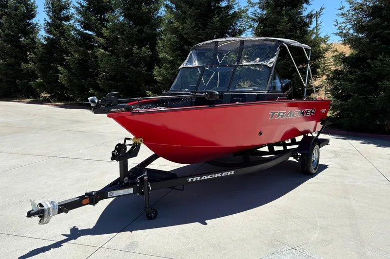 Slide: The Image of 2026 Tracker Pro Guide V-175 WT boat in vibrant red on a trailer, outdoors. - 6