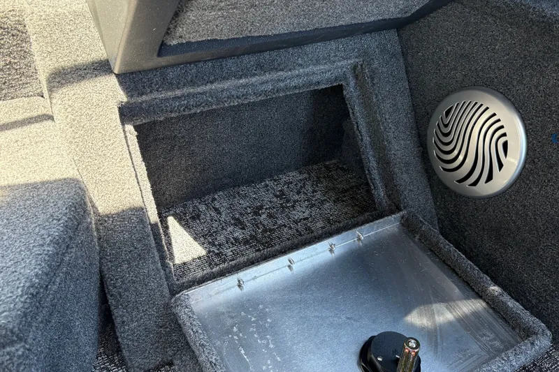 Slide: The Image of Interior of 2026 Tracker Pro Guide V-175 WT boat, featuring carpeted storage and speaker. - 33