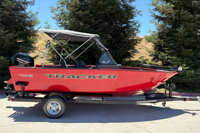 The Image of 2026 Tracker Pro Guide V-175 WT boat in vibrant red on a trailer, parked outdoors. - 0