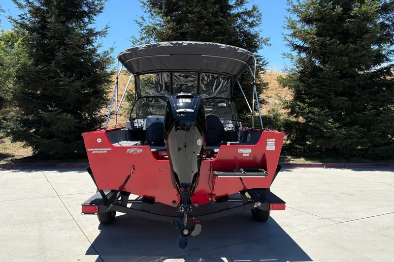 Slide: The Image of 2026 Tracker Pro Guide V-175 WT boat with outboard motor, parked outdoors. - 7