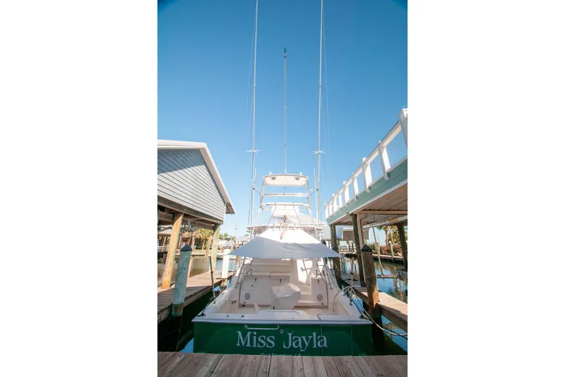 Slide: The Image of 2004 Cabo 40 Express yacht docked, featuring Seakeeper stabilization, under clear blue sky. - 11