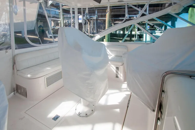 Slide: The Image of Interior of 2004 Cabo 40 Express yacht with covered seating and clear windows. - 15
