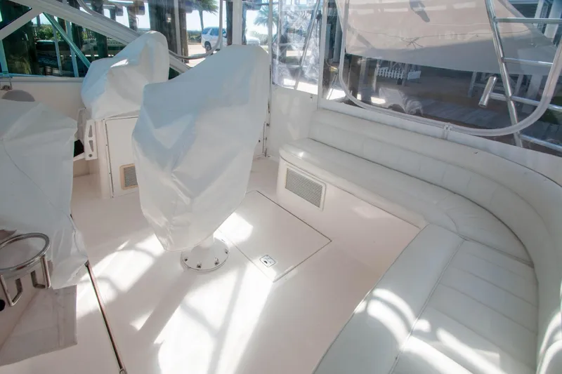 Slide: The Image of 2004 Cabo 40 Express interior with covered seats and white leather seating. - 16