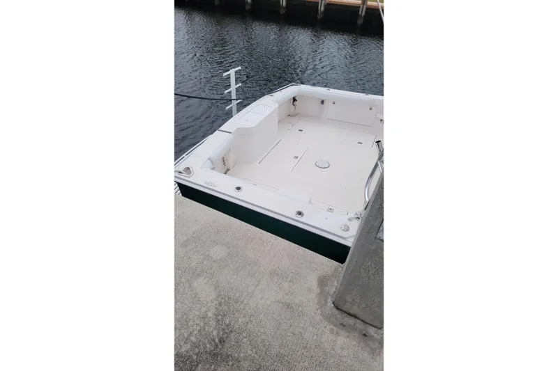 Slide: The Image of 2004 Cabo 40 Express boat docked at marina, featuring spacious deck and clean design. - 2