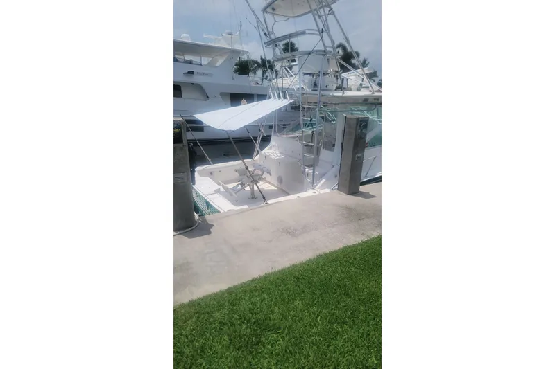 Slide: The Image of 2004 Cabo 40 Express yacht docked at marina, side view. - 3