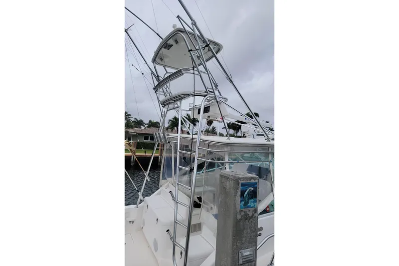 Slide: The Image of 2004 Cabo 40 Express boat with tower, docked near waterfront homes. - 4