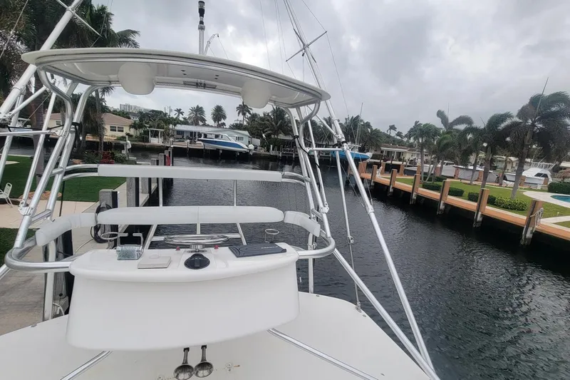 Slide: The Image of 2004 Cabo 40 Express boat docked in a scenic marina with palm trees. - 5
