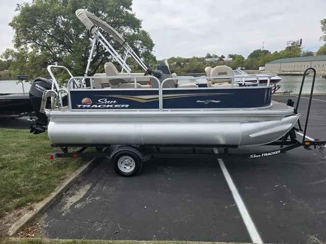 Slide: The Image of 2025 Sun Tracker Bass Buggy 16 XL Select pontoon boat parked on trailer. - 10