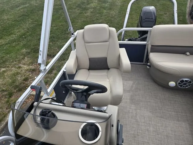 Slide: The Image of 2025 Sun Tracker Bass Buggy 16 XL Select pontoon boat interior with beige seating and steering console. - 15