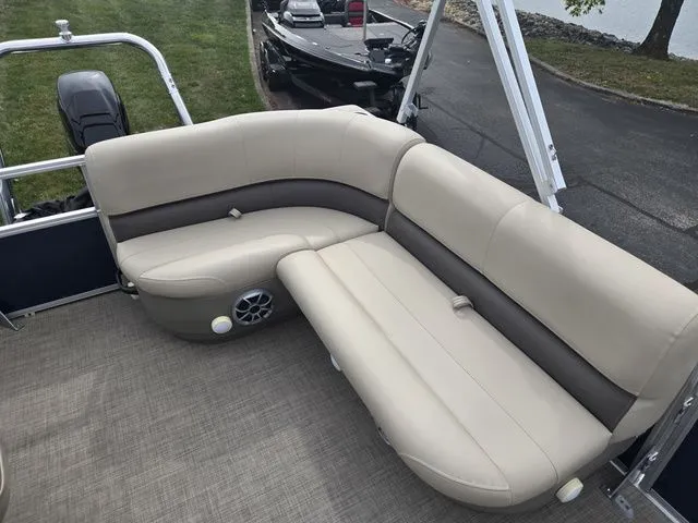 Slide: The Image of 2025 Sun Tracker Bass Buggy 16 XL Select pontoon boat with beige seating and speaker. - 16
