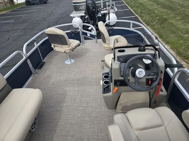 Slide: The Image of 2025 Sun Tracker Bass Buggy 16 XL Select pontoon boat interior with beige seating and steering console. - 20