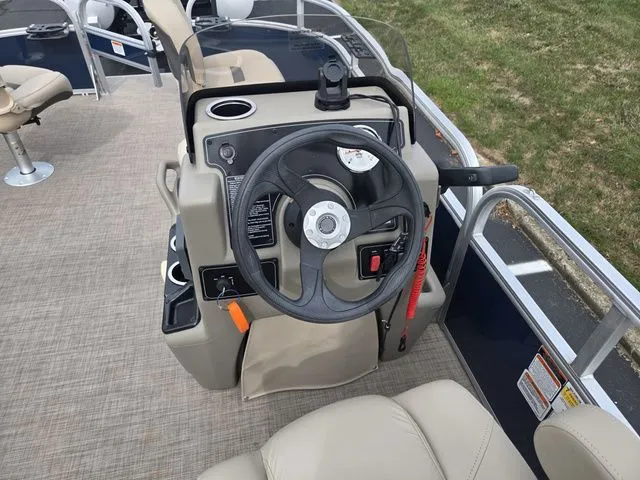 Slide: The Image of 2025 Sun Tracker Bass Buggy 16 XL Select boat steering console with beige seating. - 21