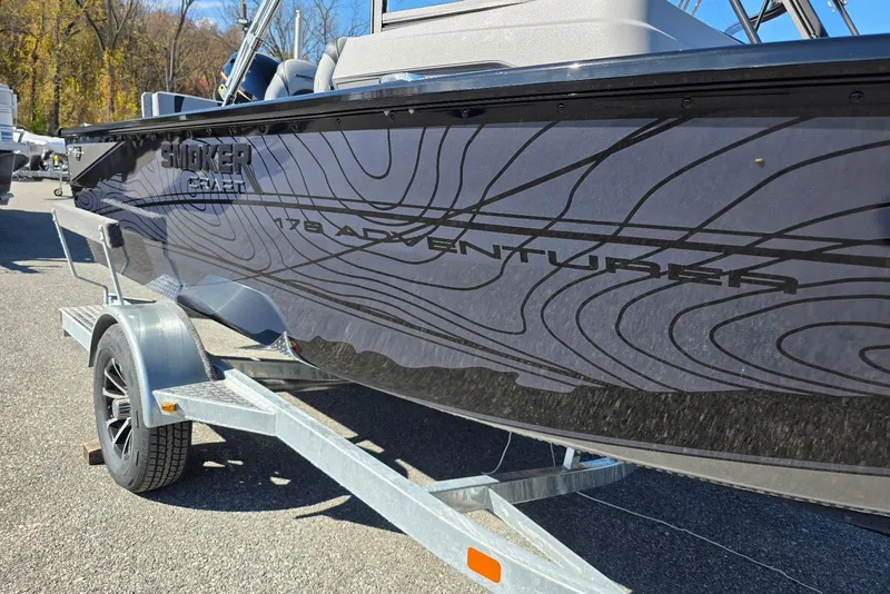 Slide: The Image of 2026 Smoker Craft Adventurer 178 DC boat on a trailer, side view. - 2