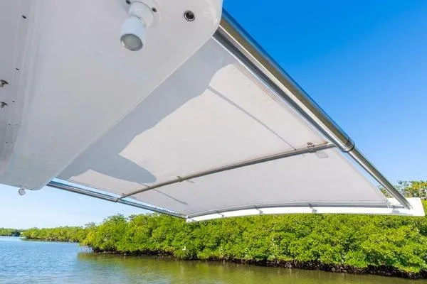 Slide: The Image of 2023 Intrepid 438 Evolution boat canopy with scenic water and greenery backdrop. - 19